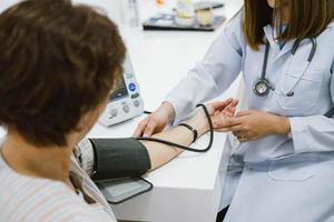 close up doctor checking senior patient blood pressure. Health care. photo