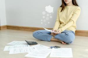 Stressed and headache asian woman with large bills or invoices no money to pay to expenses and credit card debt. shortage, Financial problems, mortgage, loan, bankruptcy, bankrupt, poor, empty wallet photo