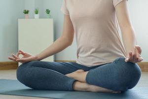 mujer haciendo yoga permanecer hogar con un meditación postura. tranquilo relajación en el Mañana para fuerte mental y físico salud. foto