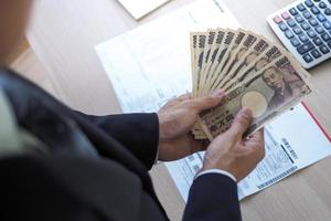 jefe estaba participación varios mil japonés billetes cada. a pagar como un bienestar fondo para empleados en el compañía. japonés moneda yen foto