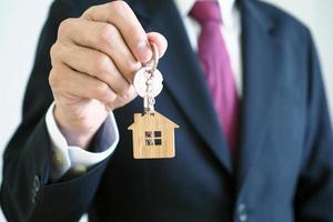 Home sales agents are giving home keys to new homeowners. Landlords and house keys concept photo