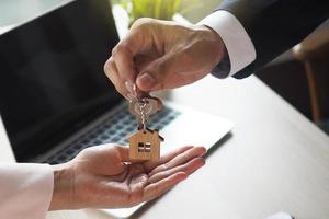 arrendatario con el arrendador. los vendedores de casas buscan las llaves de la casa para los compradores de acuerdo con un contrato de alquiler. foto