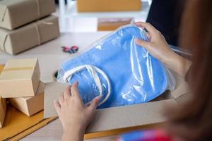 Online sellers pack the bag in the box to deliver the product to the buyer who ordered on the website. Small business photo