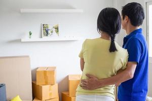 Young couples are standing happily hugging each other after helping to move things a new house. Stay at home happily and safe home. photo