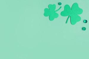 St. Patrick's Day minimalistic concept. Paper clover leaves on colored background with copy space photo