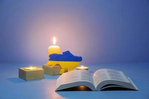 santa biblia cristiana con velas encendidas sobre fondo azul foto