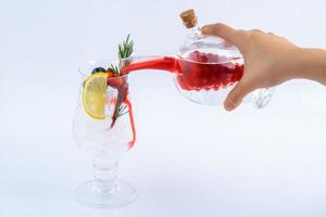 Waiter pouring strawberry juice in a glass. Beverage for summer on the white background. photo