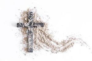 Christian cross or crucifix drawing in ash, dust or sand as symbol of religion, sacrifice, redemption, Jesus Christ, ash wednesday, lent, Good Friday, Easter with Church is devoted to fasting photo