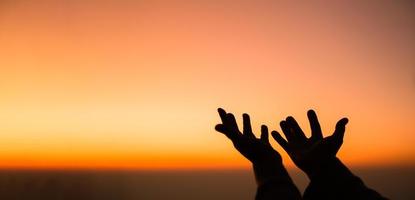 Silhouette of woman hand praying spirituality and religion, female worship to god. banner with copy space. Religious people are humble to God. Christians have hope faith and faith in god. photo