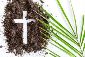 Christian cross or crucifix drawing in ash, dust or sand as symbol of religion, sacrifice, redemption, Jesus Christ, ash wednesday, lent, Good Friday, Easter with Church is devoted to fasting photo