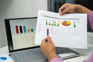 Asian accountant working and analyzing financial reports project accounting with chart graph in modern office, finance and business concept. photo