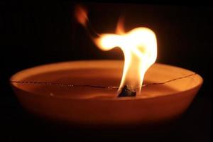 Blazing candle fire spark. Warm orange background. photo