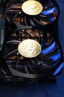 Video card with a gold coin Bitcoin on the cooler close-up. photo