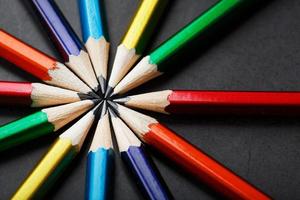 Multicolored pencils in the shape of a star on a black background. photo