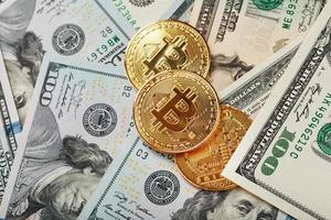 Gold bitcoin coins on the background of dollar bills with the concept of the exchange rate of the financial markets. photo
