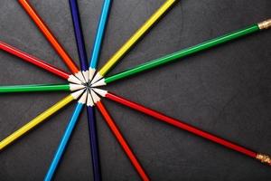 Multicolored pencils in the shape of a star on a black background. photo