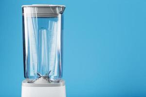 Electric blender with an empty cup on a blue background. photo
