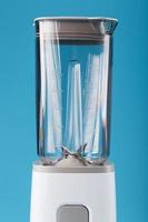 Electric blender with an empty cup on a blue background. photo