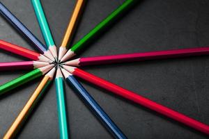 Multicolored pencils in the shape of a star on a black background. photo