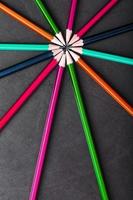 Multicolored pencils in the shape of a star on a black background. photo