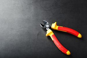 The pliers tool is red on a black background with a free space photo