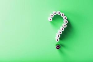 AA batteries in the form of a question mark on a green background with free space photo
