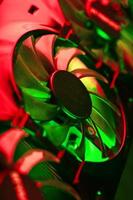 Powerful graphics card with three fans and a futuristic red-green neon backlight. photo