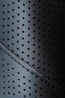 Perforated material made of black imitation leather in full screen photo