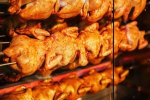 frito pollo en un escupir en un eléctrico parrilla horno. foto