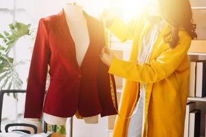 Beautiful lady blogger showing clothes in front of the camera to recording vlog video live streaming at her shop. Online Shopping Cart notion. photo