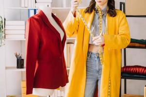 Beautiful lady blogger showing clothes in front of the camera to recording vlog video live streaming at her shop. Online Shopping Cart notion. photo