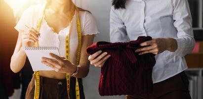 Beautiful lady blogger showing clothes in front of the camera to recording vlog video live streaming at her shop. Online Shopping Cart notion. photo
