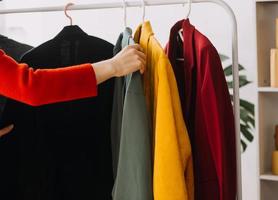 Beautiful lady blogger showing clothes in front of the camera to recording vlog video live streaming at her shop. Online Shopping Cart notion. photo