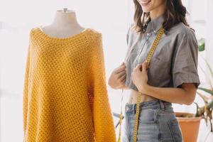 Beautiful lady blogger showing clothes in front of the camera to recording vlog video live streaming at her shop. Online Shopping Cart notion. photo