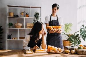 In KitchenPerfectly Happy Couple Preparing Healthy Food, Lots of Vegetables. Man Juggles with Fruits, Makes Her Girlfriend Laugh. Lovely People in Love Have Fun photo