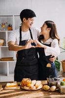 en cocina perfectamente contento Pareja preparando sano alimento, un montón de vegetales. hombre hace malabares con frutas, hace su Novia reír. encantador personas en amor tener divertido foto