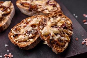 Delicious crispy toast or bruschetta with fried onion, champignon mushrooms and cheese photo