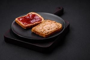 Nutritious sandwiches consisting of bread, raspberry jam and peanut butter photo