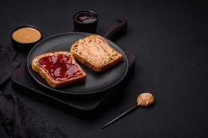 Nutritious sandwiches consisting of bread, raspberry jam and peanut butter photo