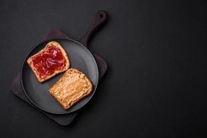 Nutritious sandwiches consisting of bread, raspberry jam and peanut butter photo