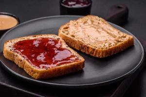 Nutritious sandwiches consisting of bread, raspberry jam and peanut butter photo