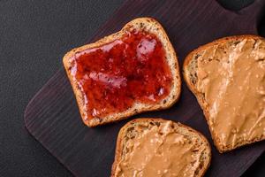 Nutritious sandwiches consisting of bread, raspberry jam and peanut butter photo