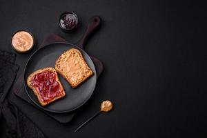 Nutritious sandwiches consisting of bread, raspberry jam and peanut butter photo