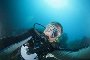 A scuba diver gone crazy try to open porthole from underwater photo