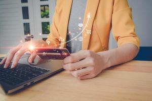 Business woman in yellow suit using laptop online banking and make payment, Young girl using computer with credit card, Mobile banking network, online payment, digital marketing, business technology. photo