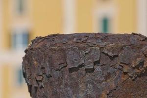 Rusted Bollard on colorful building background photo