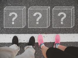 A man and woman handing out on the street with boxes with question marks on the pavement, surprise, reward, top view. photo