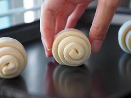 hand of girl picking or dropping Raw Croissant Flour rolled up in layers photo