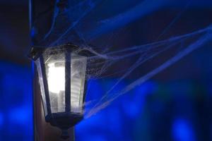 spider web covered lamp in the black background photo