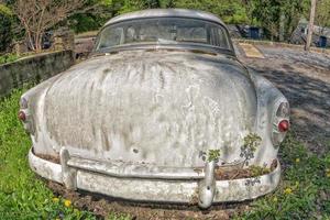 viejo coche oxidado abandonado en un campo foto